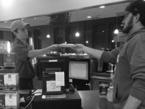 Senior A.J.’s employee Gregg Coughlin serves a customer a quesadilla.  (Carly Howell/Collegian) 