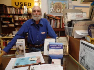 Richard Wunsch, owner of BASCH, with books from local authors. Breana Noble | Collegian 