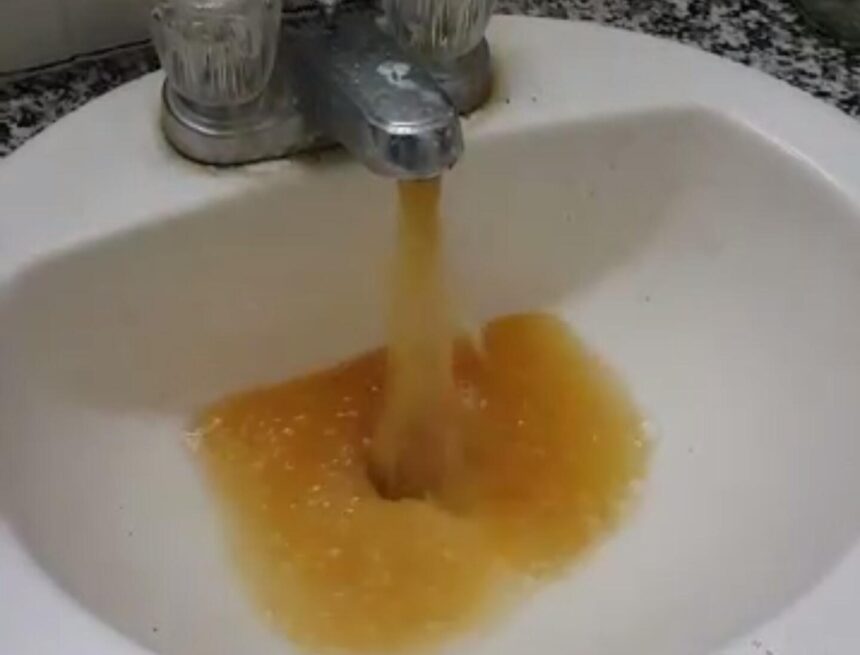 Yellow water pours from a faucet in the Alpha Tau Omega house (courtesy Denton Williams)