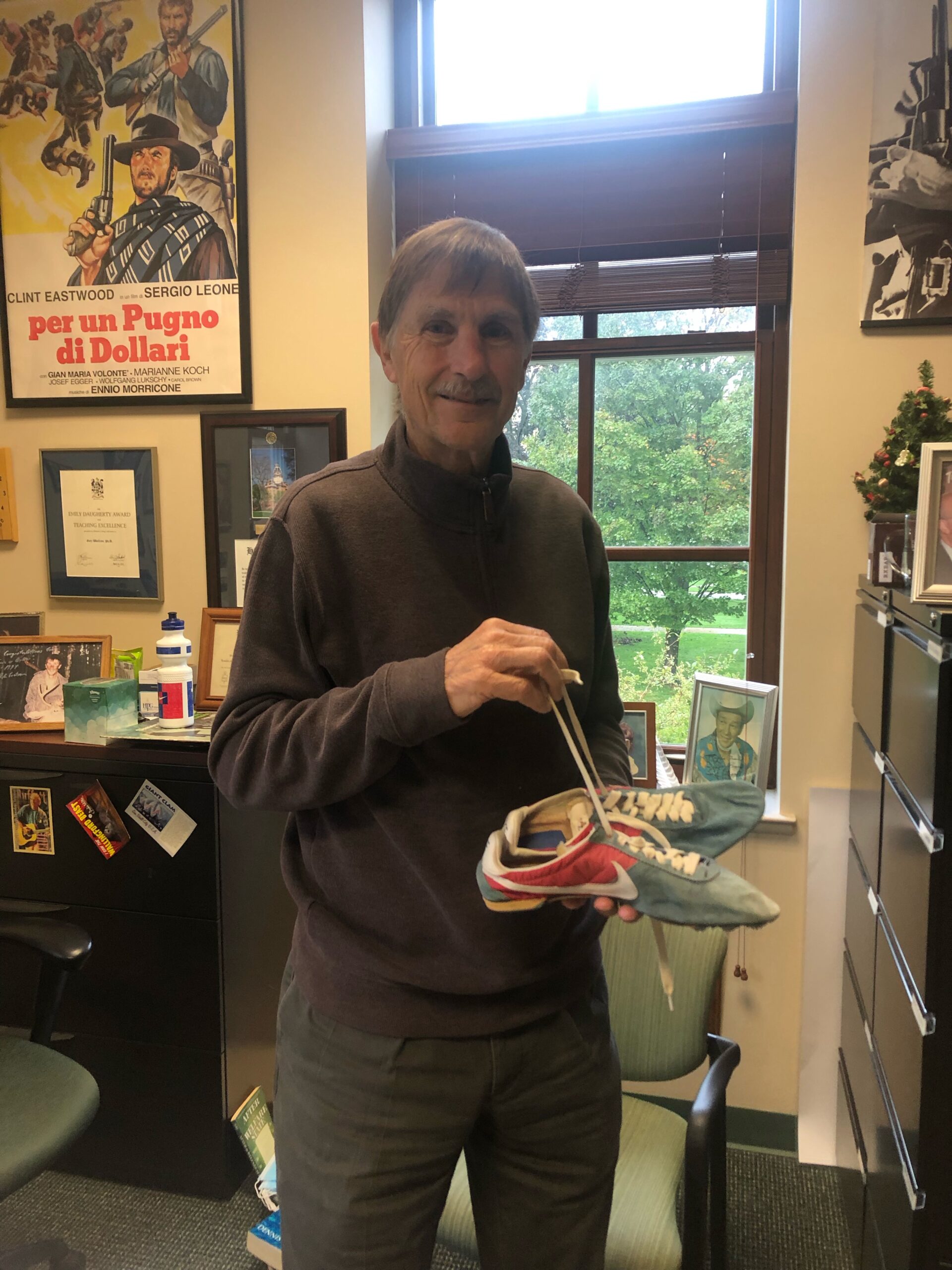 Gary Wolfram holds the shoes of record-breaking runner Henry Rono. Collegian | Aubrey Gulick