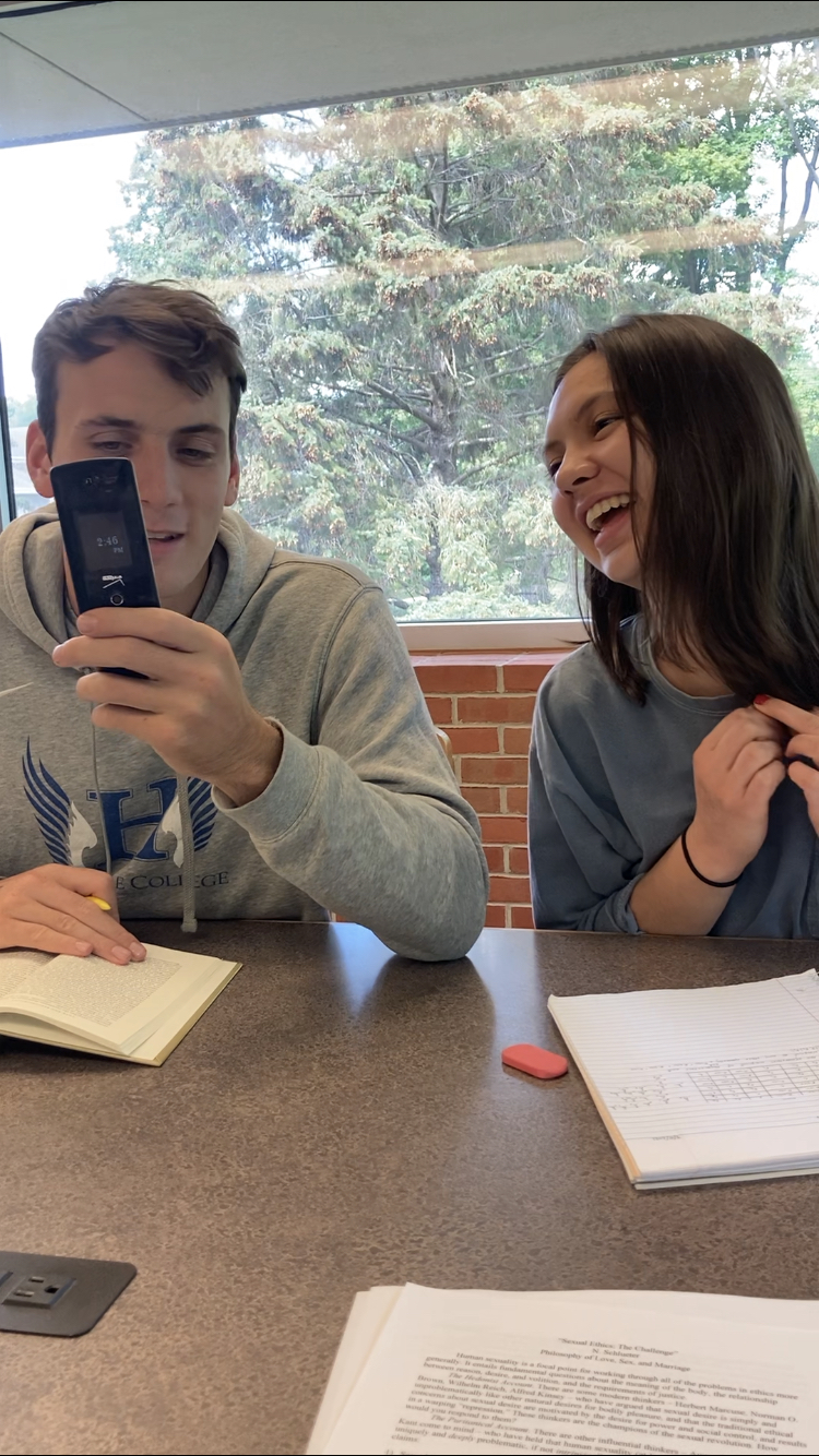 Cousins Benjamin and Marie Raffin enjoy looking at a flip phone. Collegian | Olivia Hajicek